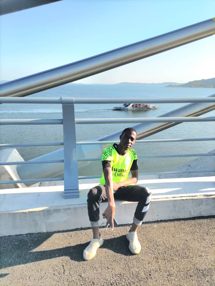 Junior sitting on the bridge beside the lake.