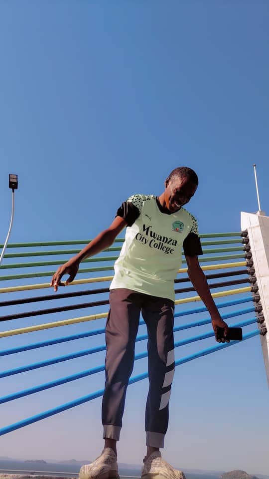 Junior laughing on a bridge with colorful railings.